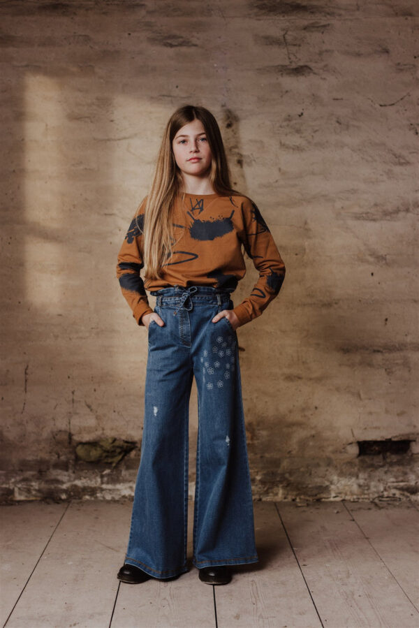 Little Hedonist high-waist wide-leg pants with elastic band in the waist. Denim authentic indigo with stitched flowers. Easy to wear and match, with a strap to finish the look. Sustainable kids clothing made form organic cotton.