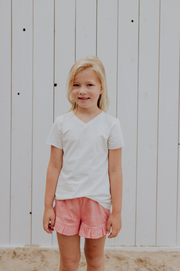 Little Hedonist ruffled short in Coral Almond for girls. Made from organic soft muslin. Sustainable kids clothing.